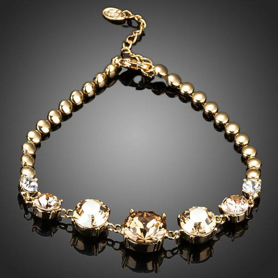 KHAISTA gold plated CZ charm bracelet on white background