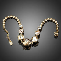 Close up detail of KHAISTA gold plated CZ charm bracelet