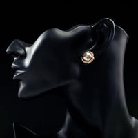 Side angle view of KHAISTA gold plated dome shaped stud earrings