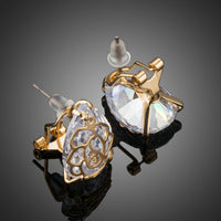 Close up of KHAISTA gold plated flower shaped CZ earrings