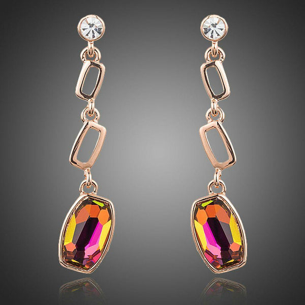 KHAISTA gold plated curved crystal drop earrings on white background