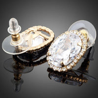 Close up of KHAISTA gold plated oval stud earrings