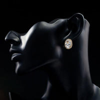 Side angle view of KHAISTA gold plated oval stud earrings
