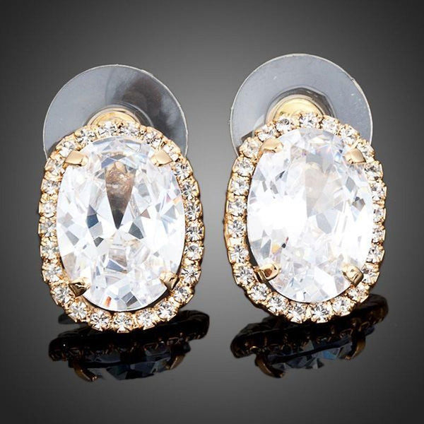 KHAISTA gold plated oval stud earrings on white background