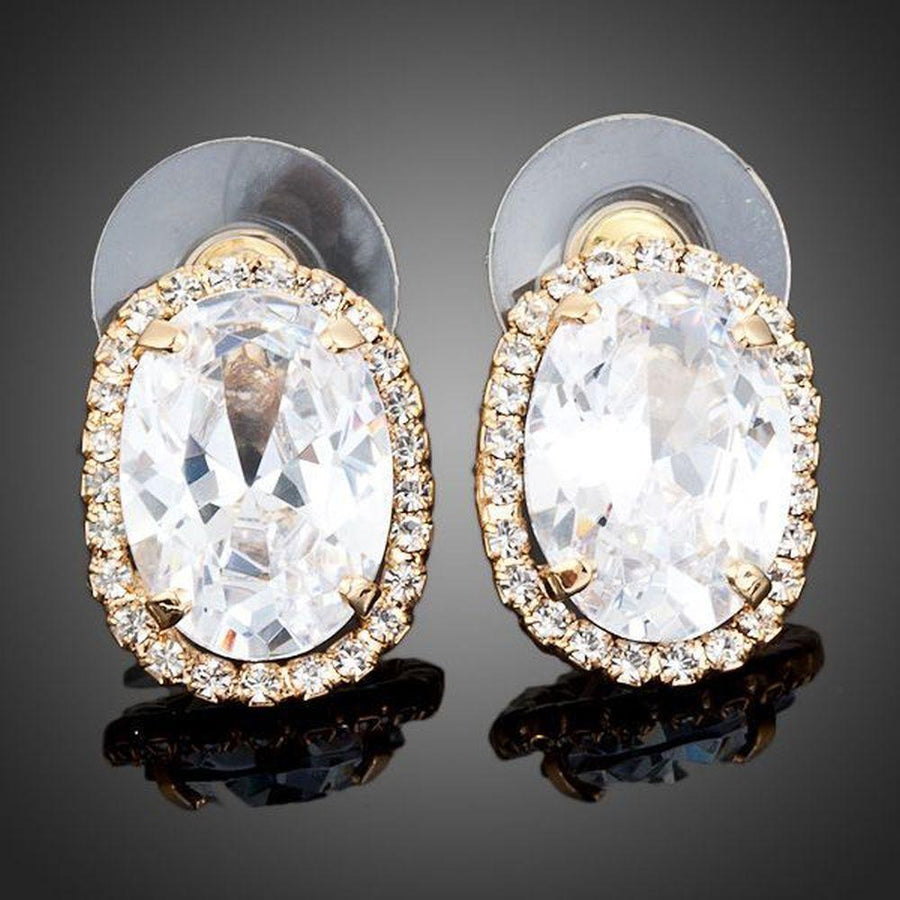 KHAISTA gold plated oval stud earrings on white background