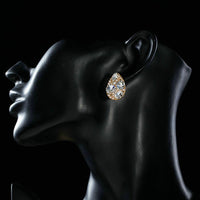 Side angle view of KHAISTA gold plated pear cut stud earrings