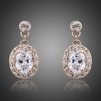 KHAISTA gold plated prolate crystal drop earrings on white background