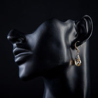 Side angle view of KHAISTA gold plated raindrop crystal drop earrings
