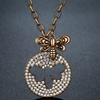 Close up detail of KHAISTA gold crystal bee pendant necklace