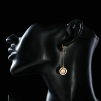 Side angle view of KHAISTA golden CZ drop earrings