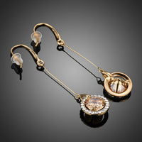 Close up of KHAISTA golden CZ drop earrings