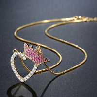 Side angle view of KHAISTA gold heart crown CZ pendant necklace