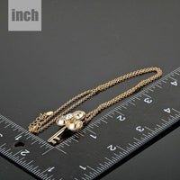 Pendant detail on KHAISTA gold crystal key pendant necklace