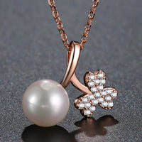 Side angle view of KHAISTA gold pearl pendant necklace