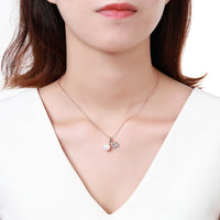 Close up detail of KHAISTA gold pearl pendant necklace