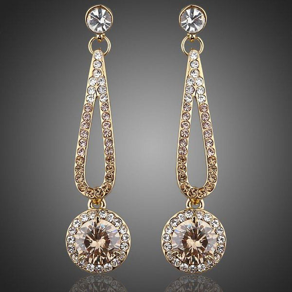 KHAISTA golden round CZ drop earrings on white background