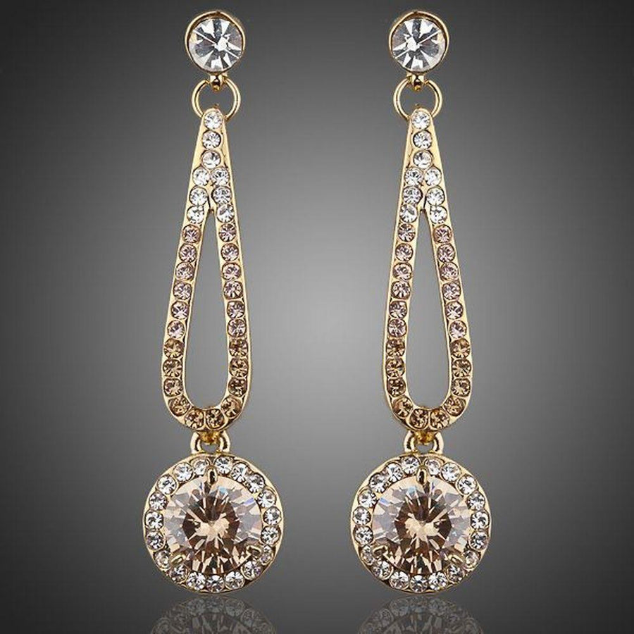KHAISTA golden round CZ drop earrings on white background