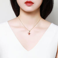 Side angle view of KHAISTA gold crystal tortoise pendant necklace