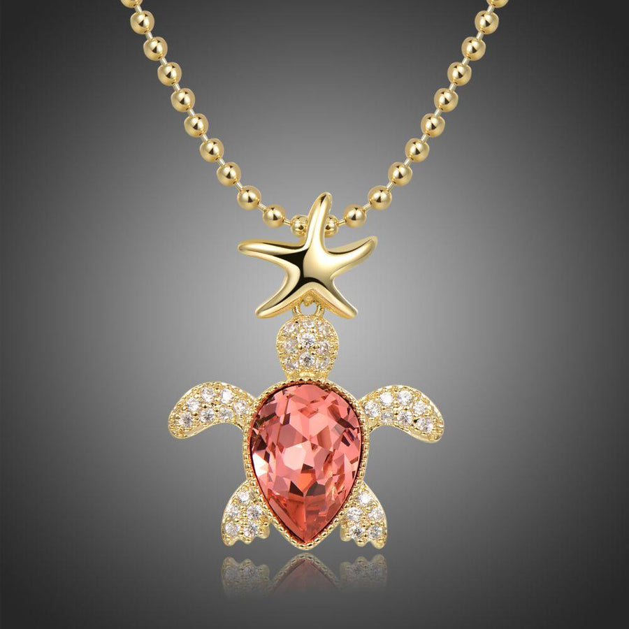 KHAISTA gold crystal tortoise pendant necklace on white background