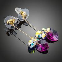 Close up of KHAISTA gradient heart crystal drop earrings