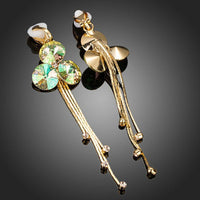 Side angle view of KHAISTA gradual change crystal drop earrings