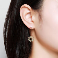 Side angle view of KHAISTA green CZ statement earrings