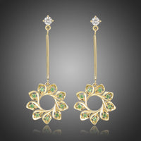 KHAISTA green CZ statement earrings on white background