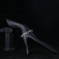 Side angle view of KHAISTA green glam CZ bracelet