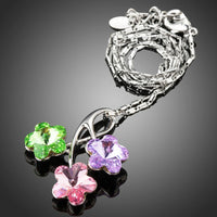 Side angle view of KHAISTA green pink purple flower pendant necklace