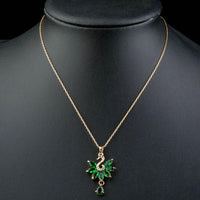 Close up detail of KHAISTA green crystal swan pendant necklace