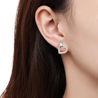 Side angle view of KHAISTA blue Austrian crystal heart stud earrings