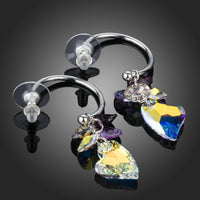 Close up of KHAISTA heart charm crystal drop earrings