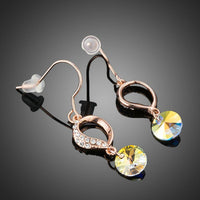 Side angle view of KHAISTA gradual change heart dangle drop earrings