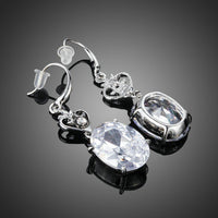 Close up of KHAISTA heart design oval crystal drop earrings