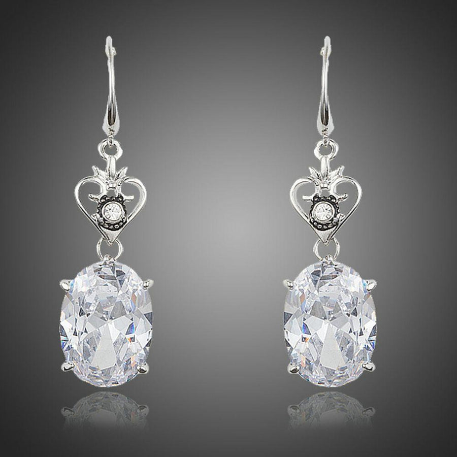 KHAISTA heart design oval crystal drop earrings on white background