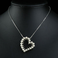 Side angle view of KHAISTA heart shaped pearl pendant necklace