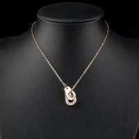 Side angle view of KHAISTA hook link chain crystal necklace