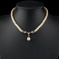 Close up detail of KHAISTA imitation pearl love crystal necklace