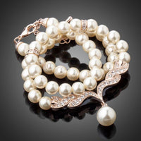 Side angle view of KHAISTA imitation pearl love crystal necklace