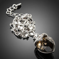 Side angle view of KHAISTA ink brown crystal pendant necklace