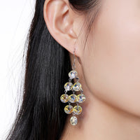 Close up of KHAISTA interconnected crystal drop earrings