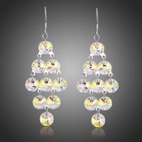 Side angle view of KHAISTA interconnected crystal drop earrings