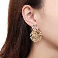 Side angle view of KHAISTA irregular round crystal drop earrings