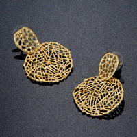 Close up of KHAISTA irregular round crystal drop earrings