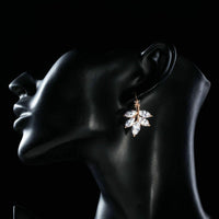 Side angle view of KHAISTA leaf shaped zircon drop earrings