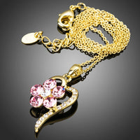 Side angle view of KHAISTA light gold pink crystal flower necklace