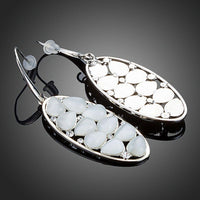 Close up of KHAISTA light grey crystal oval drop earrings