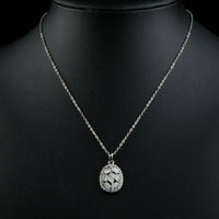 Side angle view of KHAISTA light grey oval crystal necklace