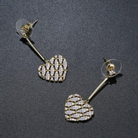 Side angle view of KHAISTA light pink zirconia heart drop earrings