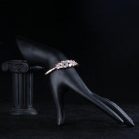 Side angle view of KHAISTA lightweight crystal feather bangle